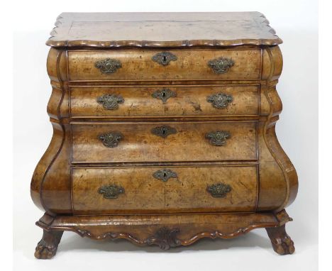 An 18th century Dutch burr oak bombe commode, having a shaped top above four long graduated drawers, all raised on claw and b