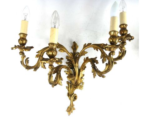 A pair of Rococo Revival gilt metal four-light candelabra, each swept and adorned with acanthus leaves, drilled for electrici