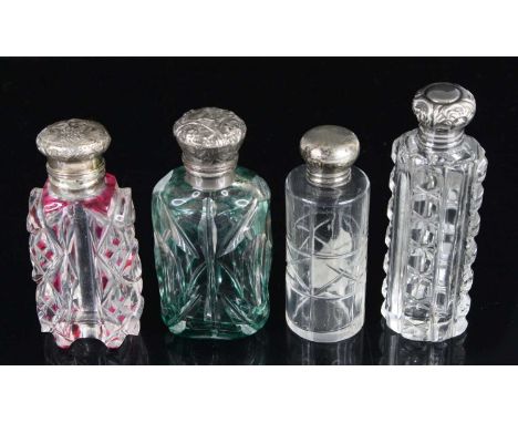 A Victorian scent bottle, having a ruby overlaid and clear cut glass body, the hinged white metal cover embossed with leaves 