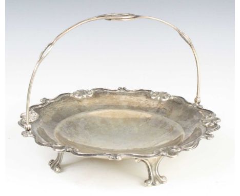 A late 19th century Chinese silver swing handled table basket, of shaped circular form with repousse scrolling cloud decorati