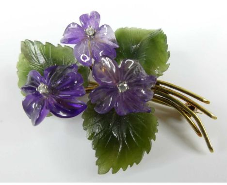 A yellow metal stylised floral spray brooch, comprising three movable carved amethyst flowers each with a centre 1.9mm round 