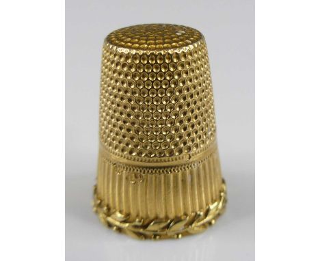 A yellow metal engraved thimble, with leaf work detail around base, dia.15mm, gross weight 4.4g, not hallmarked but stamped 1