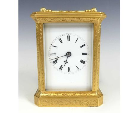 A late 19th century French gilded brass carriage clock, the case with all-over trailing scroll leaf engraved decoration, cant