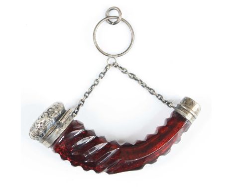 A Victorian scent bottle of cornucopia shape, having a facet cut ruby glass body with hinged white metal cap and mount united