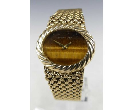 A Bueche Girod lady's 9ct gold manual wind wristwatch, having a signed "tiger's eye" oval dial, dia. 28mm within a spiral ree