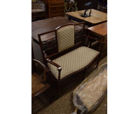 An Edwardian two seater sofa with fretwork back and serpentine front