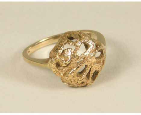 GOLD RING. A modern 9ct. gold dress ring with pierced, textured front. (M).