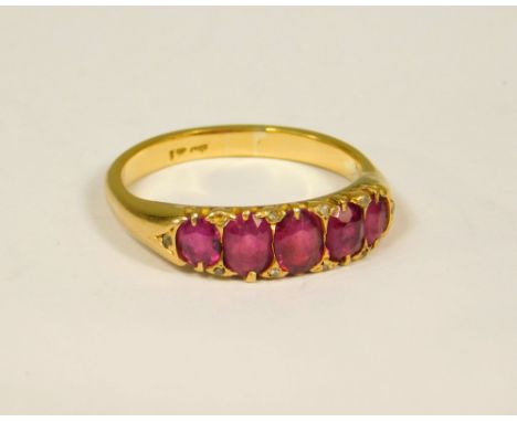 RUBY RING. An 18ct. gold, five stone ruby ring, further set with small native cut diamonds. (One diamond missing). (O/P).