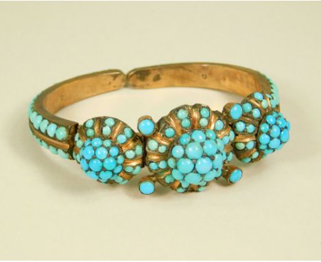 TURQUOISE BANGLE. A torque bangle set throughout with cabouchon turquoise. Max. depth 2.4cm.