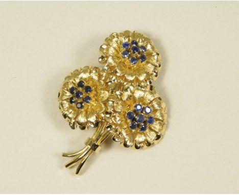 SAPPHIRE BROOCH. AN 18ct. gold flower spray brooch, set with three clusters of sapphires. 4.4 x 3cm.