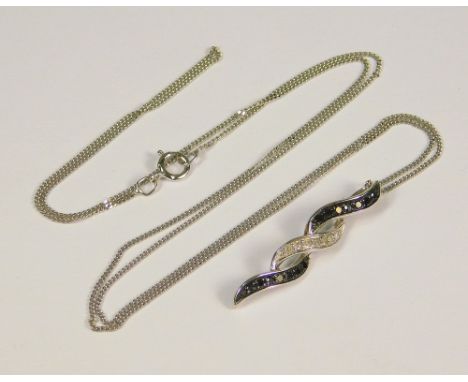 GOLD PEDANT. A 9ct. white gold pendant set with black &amp; white diamonds on a white gold chain.