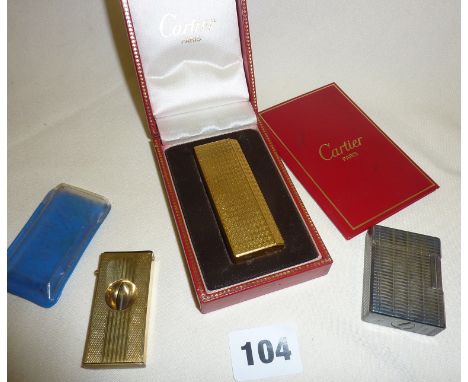 A Cartier gold plated gas lighter with box, an S. Dupont of Paris lighter and a gold plated cigar cutter