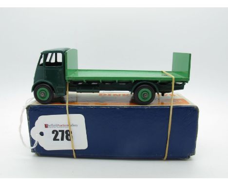 A Boxed Original Dinky #513 Guy Flat Truck, with tailboard. First type dark green cab and chassis, mid green back and grooved