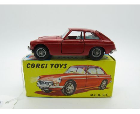 A Boxed Original Corgi #327 M.G.B. G.T; dark red body, light blue interior, spoked wheels, black suitcase, jeweled headlamps.
