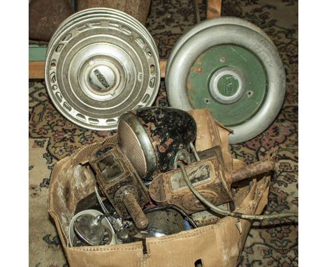 Four vintage Jaguar hub caps and two Leyland hub caps together with a box of vintage headlamps and other lamps