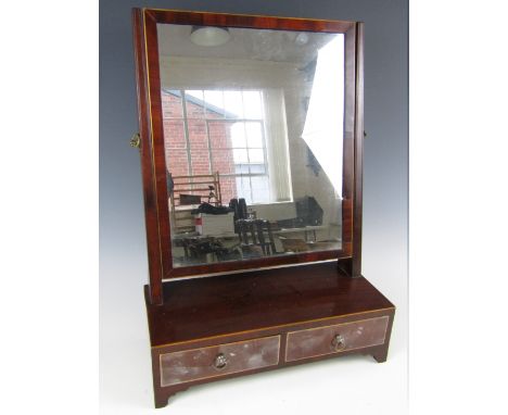 A George III mahogany swivel toilet mirror, with box-wood string edging and a base of two drawers with brass axe-head handles
