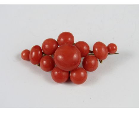 A vintage coral brooch, comprising a terraced arrangement of polished pink coral set on a yellow metal frame and pin, 5 cm