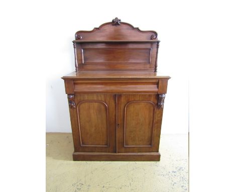 An early Victorian mahogany chiffonier, having an arched back with shelf, 'secret' frieze drawer and a pair of arch-panelled 