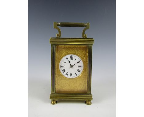 A late 19th / early 20th Century French carriage clock, the circular enamel face having foliate-engraved gilt mask