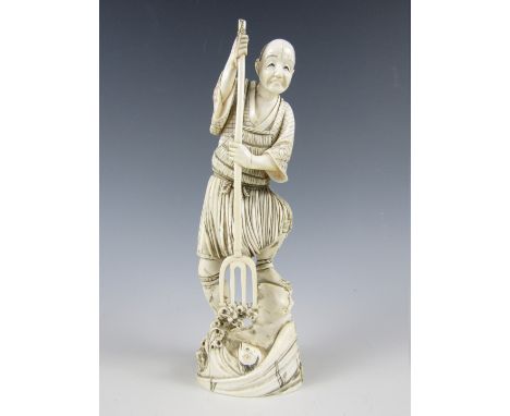 A Meiji Japanese carved ivory okimono modelled as a fisherman with trident plunging the latter towards a fish swimming amongs