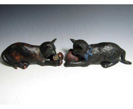 Two Bretby terracotta cats, modelled respectively playing with a ball of wool and a bobbin