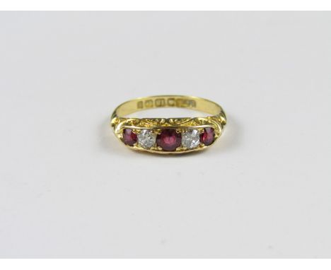 An Edwardian ruby and diamond ring, comprising three rubies, the largest of which of approximately .33 carat, divided by diam