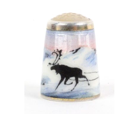 A Norwegian silver gilt and enamel moonstone top thimble by Aksel Holmsen, depicting a single reindeer pulling a Sami in a sl