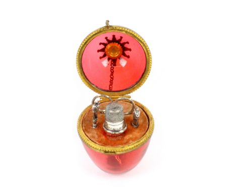 A French ruby glass and gilt mounted ring and chain etui for a child, circa 1860, the egg with gilt brass hinge mount and cre
