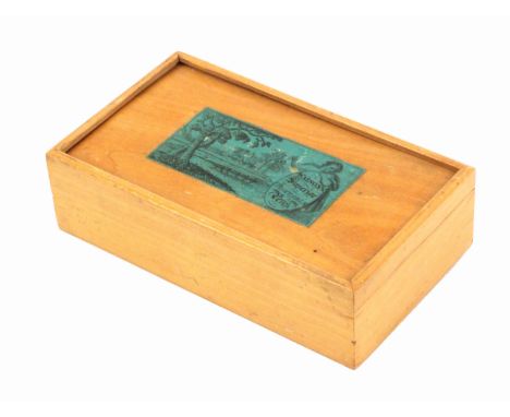 A white wood advertising labelled Tunbridge ware writing box, of rectangular form, the sliding lid with a black on green rura