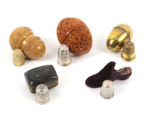 Five thimble cases each with a thimble, comprising a velvet slipper with silver thimble, 6cms, a vegetable ivory acorn with b