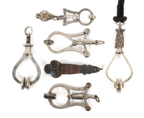 Six skirt lifters, comprising a screw top example on cord, 12cms, another stamped 'E.G. Depose', 10cms, an unusual sprung clo