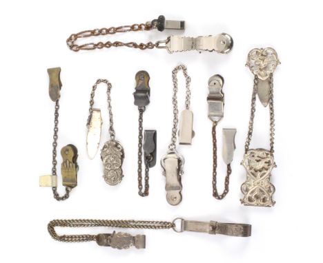 Eight skirt lifters all on chatelaine style hooks, and chains comprising two decorative spring clip examples, largest 5.5cms 