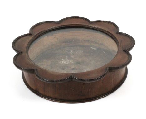 An Edwardian mahogany circular table display cabinet, the circular glazed flower head form top with moulded edge hinged to a 
