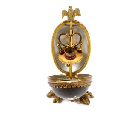 A French sewing etui for a child, circa 1860, the gilt metal floral cast base supporting a gilt metal mounted porcelain egg o