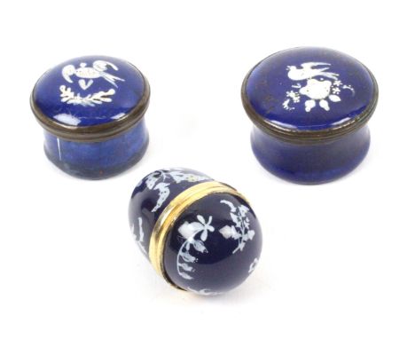 Two early 19th Century blue enamel circular boxes and a later thimble egg, the circular boxes each decorated in white enamel 