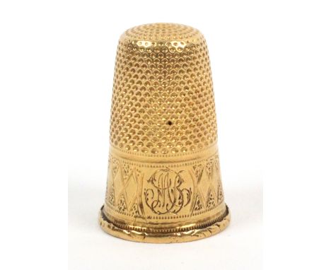 A gold thimble, unmarked, probably French, with initialled and engraved frieze over a floret rim.