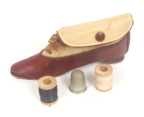A novelty sewing companion in the form of a shoe, circa 1920, in brown leather and cloth with lace, interior with two wooden 
