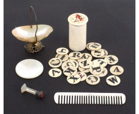 A group of objects, comprising mother of pearl comb and circular mirror, mother of pearl pin basket, a bone alphabet cylinder