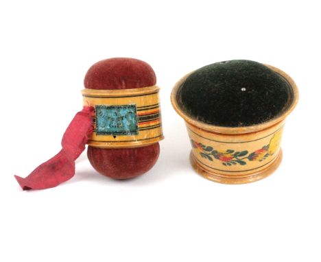 Two white wood paint and label decorated Tunbridge ware pin cushions, comprising a double ended girdle form example with ring