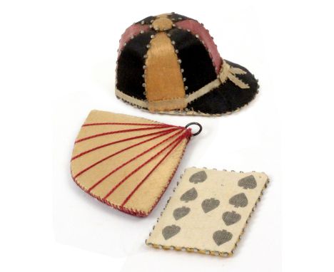 Three silk pin cushions, comprising a good jockey cap example, pin stuck edges and segments, 5.5cms, a fan form example, 7cms