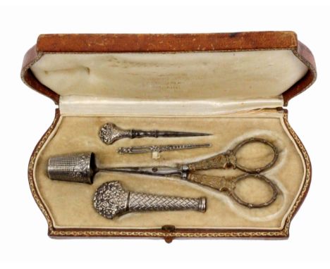 A French etui, circa 1900, the gilt tooled leather case of shaped end rectangular form, the interior with elaborate silver to
