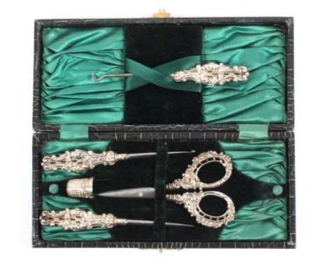 A cased set of four silver mounted sewing tools, the simulated crocodile rectangular case lined in silk and velvet, the tools