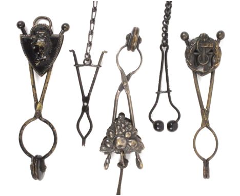 Five black finish mourning skirt lifters, comprising a scissor form example with shield form slider incorporating a classical