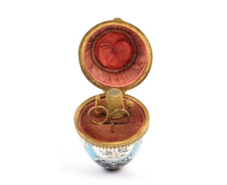A rare ring and chain child's etui of egg form, circa 1850, the porcelain egg with gilt metal mounts and painted with semi ci