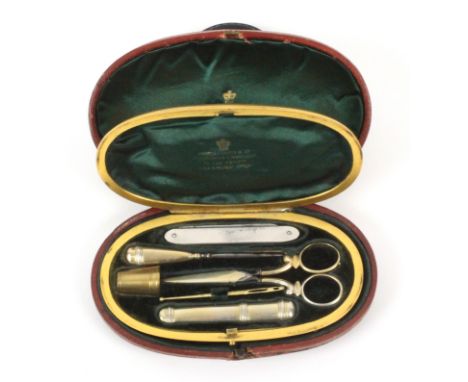 An English gilt brass sewing companion complete with outer leather case, circa 1860, the hinged oval gilt brass case lined in