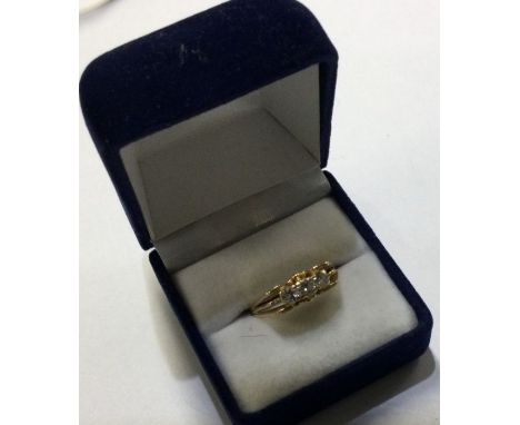 An 18 carat gold and diamond mounted three stone ring. Approx. 5 grams. Est. £100 - £150.