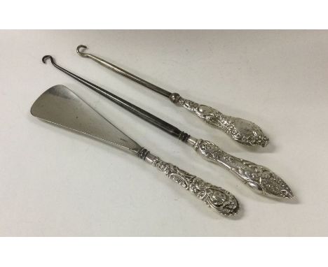 A collection of silver handled button hooks and a shoe horn. Approx. 116 grams. Est. £20 - £30.