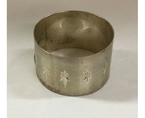 An unusual silver napkin ring with star decoration. Birmingham 1965. By H J Cooper. Approx. 18 grams. Est. £20 - £30.