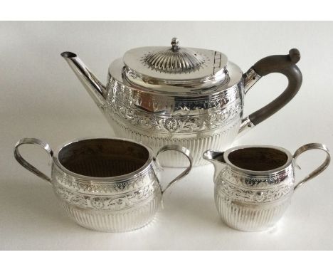 An attractive chased silver bachelor's three piece tea service. London. By EH. Approx. 468 grams. Est. £250 - £300.