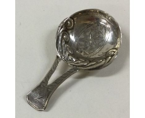 A scroll decorated Georgian silver caddy spoon. Birmingham. By TP. Approx. 6 grams. Est. £70 - £80.